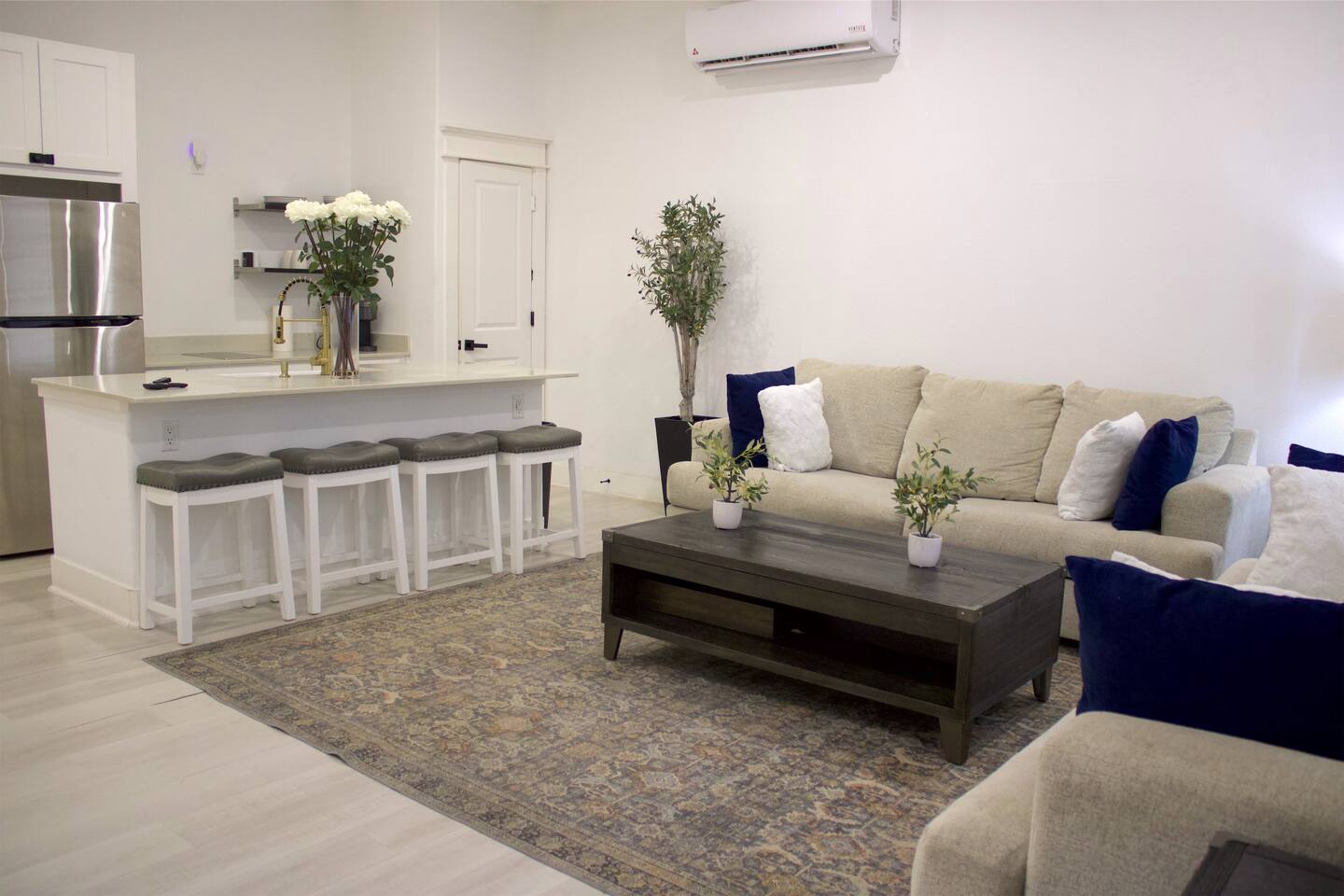 Unit 2 studio with a sofa, coffee table, and bar seating at the kitchenette counter
